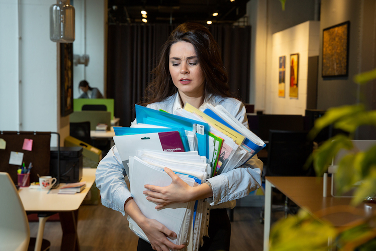woman holding lots folders